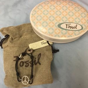 Rhinestone studded peace sign with leather band.